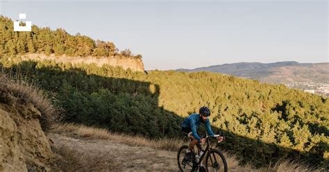 A man riding a bike down a dirt road photo – Free Mountains Image on ...